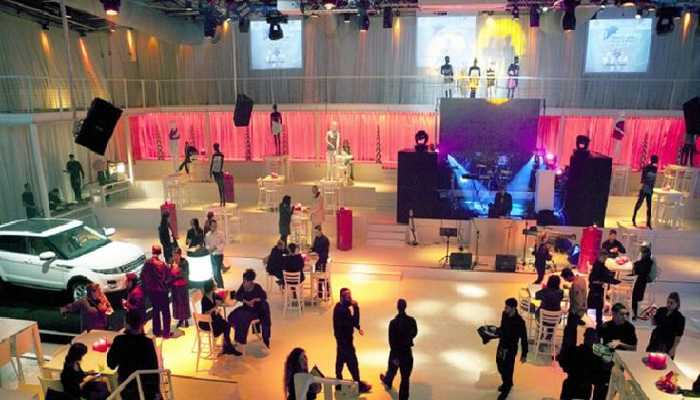 A group of people standing and arranging the lightings of the event hall.